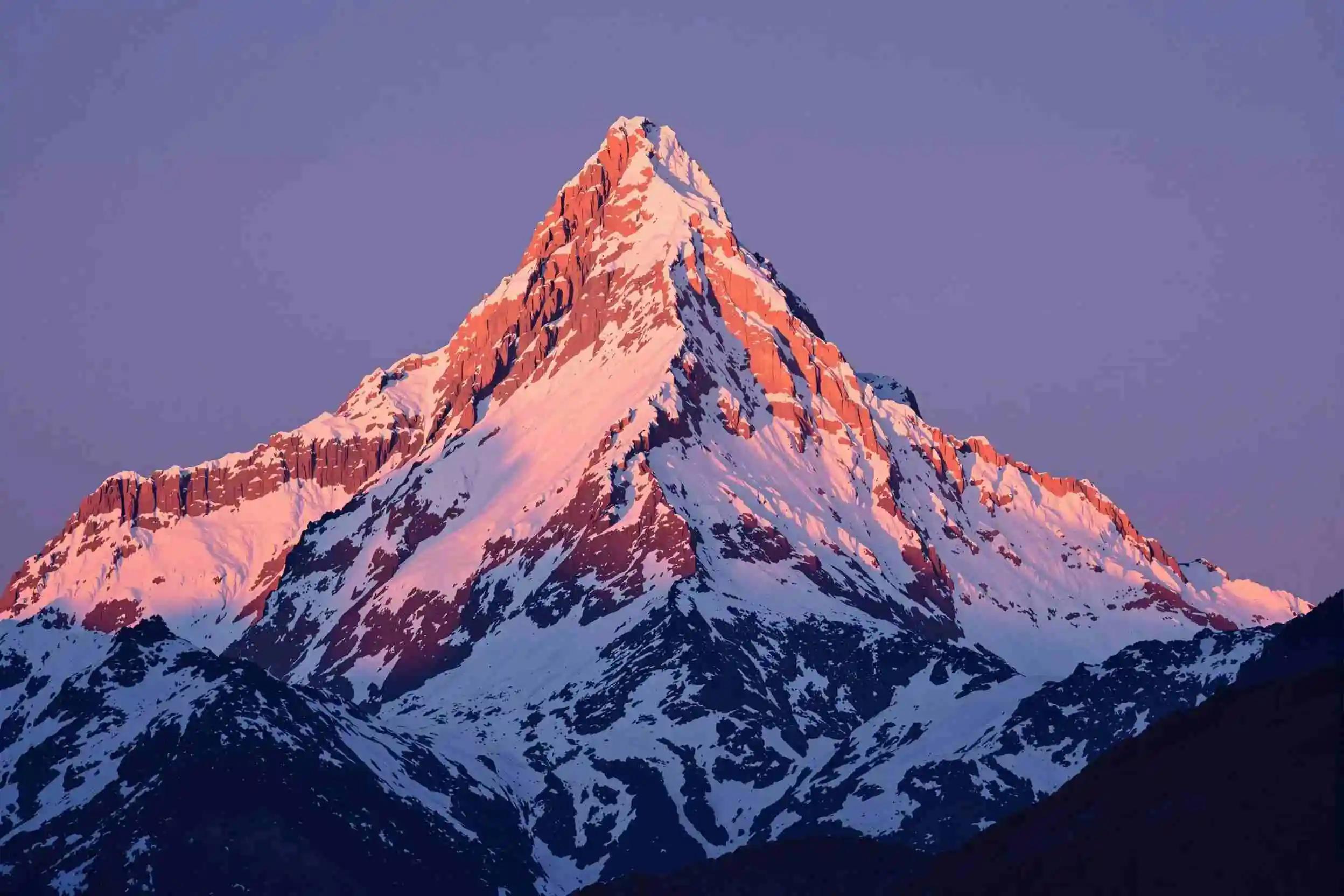 a majestic snow-capped mountain peak bathed in a warm glow of the setting sun